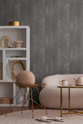The Basalt Foundry | Charcoal Slate Luxe wallpaper hung behind a blush boucle pouf and white open shelving in a living corner