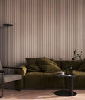 The Fluted Gallery | Driftwood Taupe Luxe wallpaper hung behind an olive green sofa, floor lamp and side table in a living room