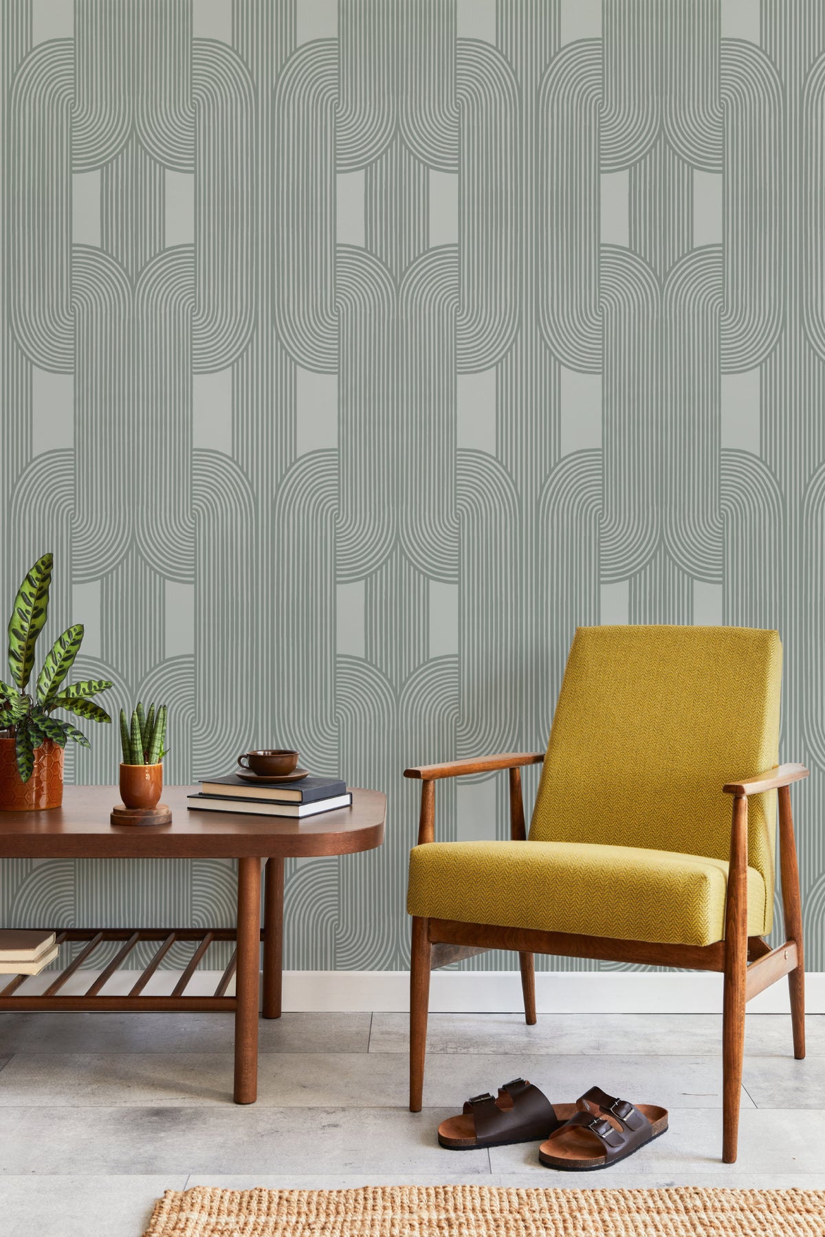 The Arcade Curve wallpaper in soft sage behind seating in a living room