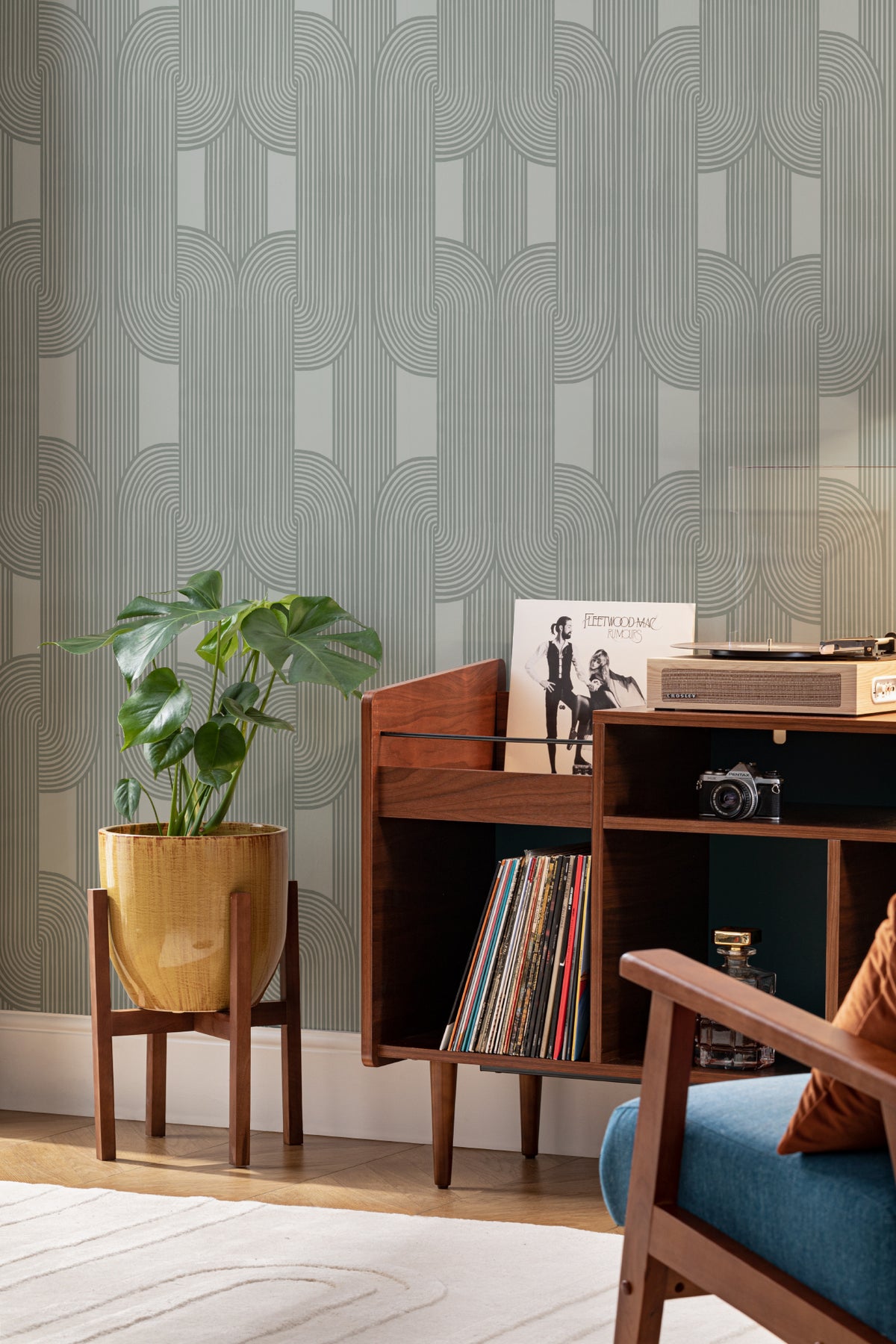 The Arcade Curve wallpaper in soft sage behind a desk in a home office
