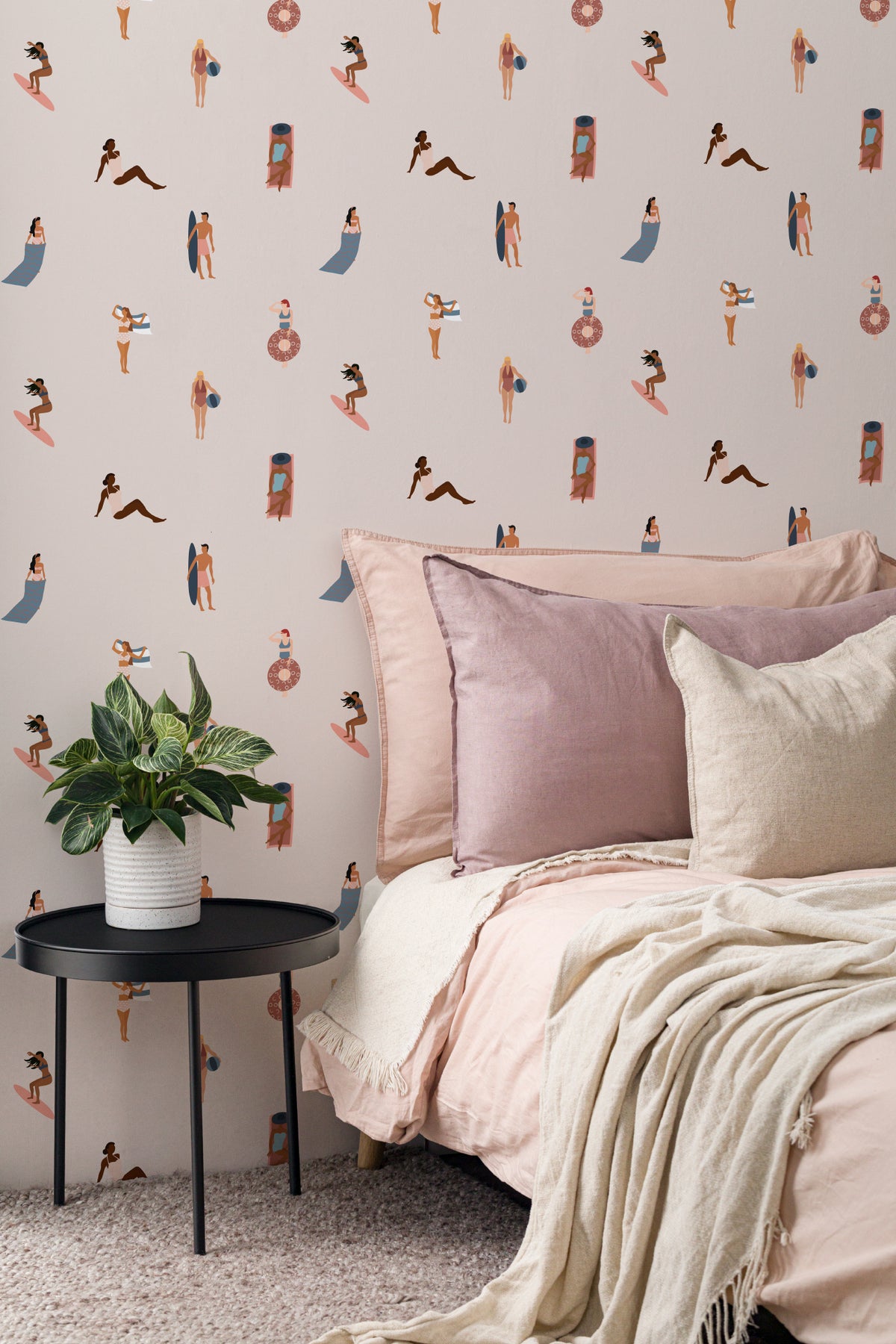 The Bathing Promenade wallpaper in shell pink and cream behind the bed in a bedroom