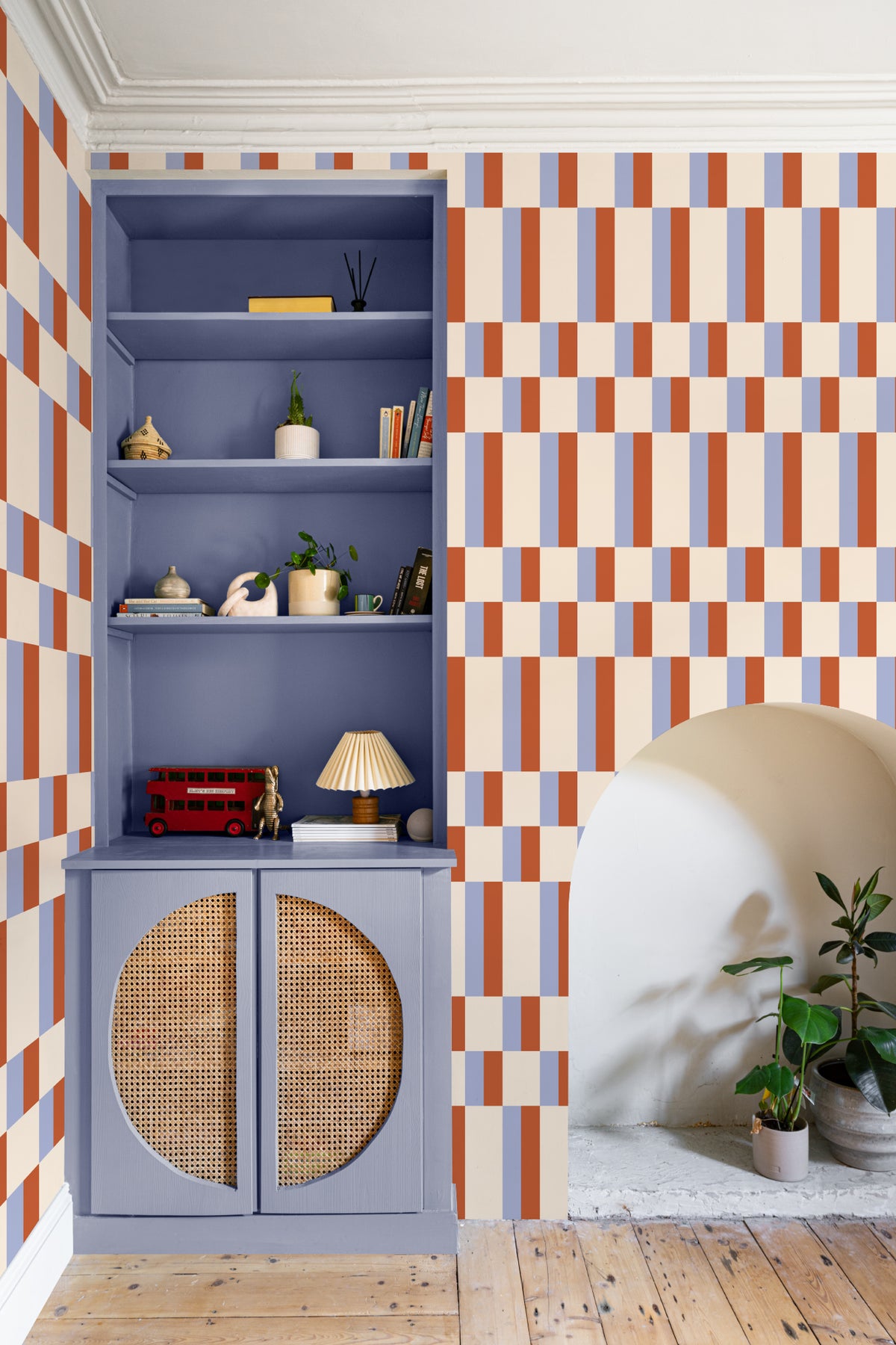 The Bauhaus Block wallpaper in periwinkle and rust behind a styled console