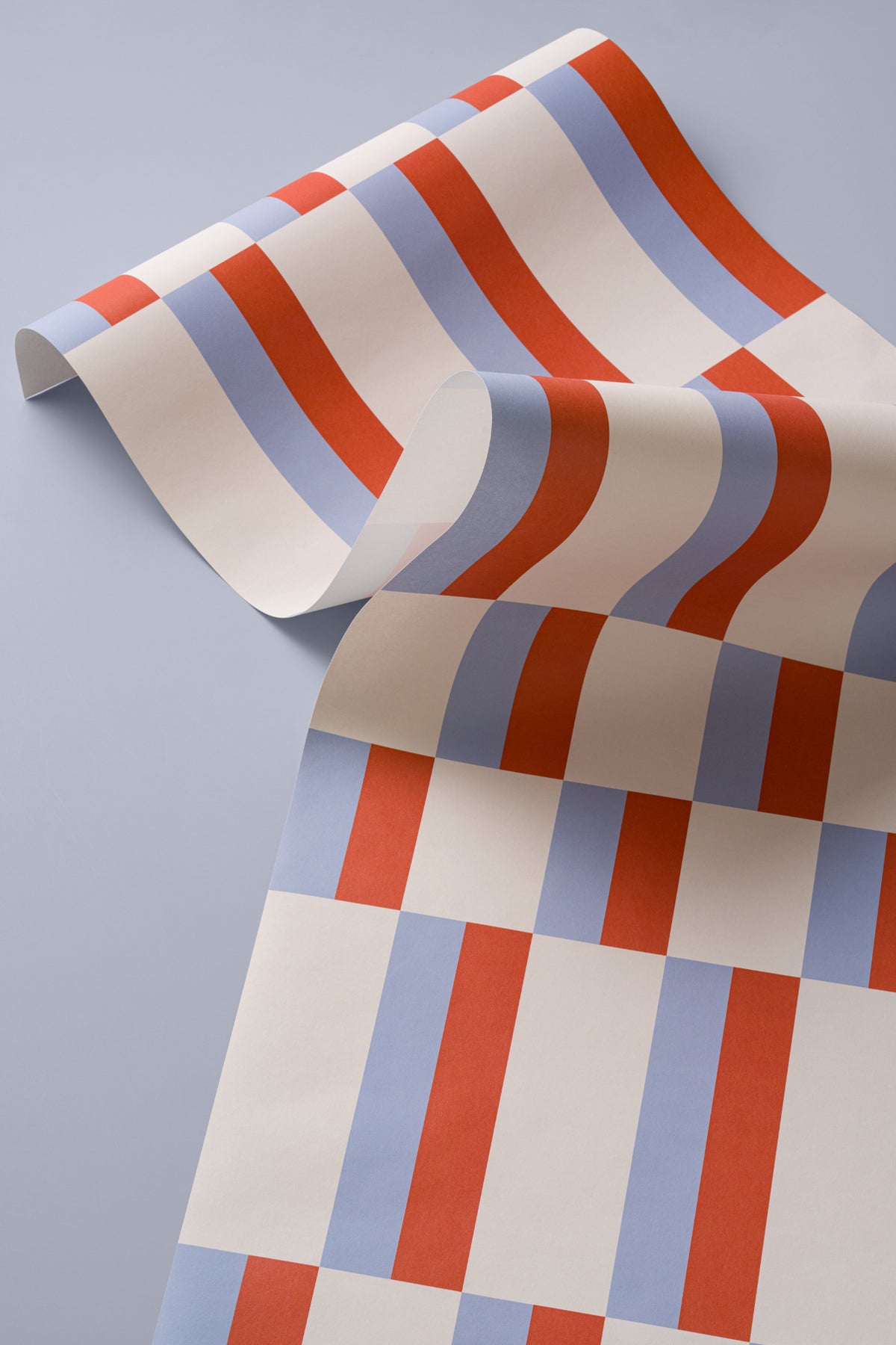 Angled detail of The Bauhaus Block wallpaper in periwinkle and rust