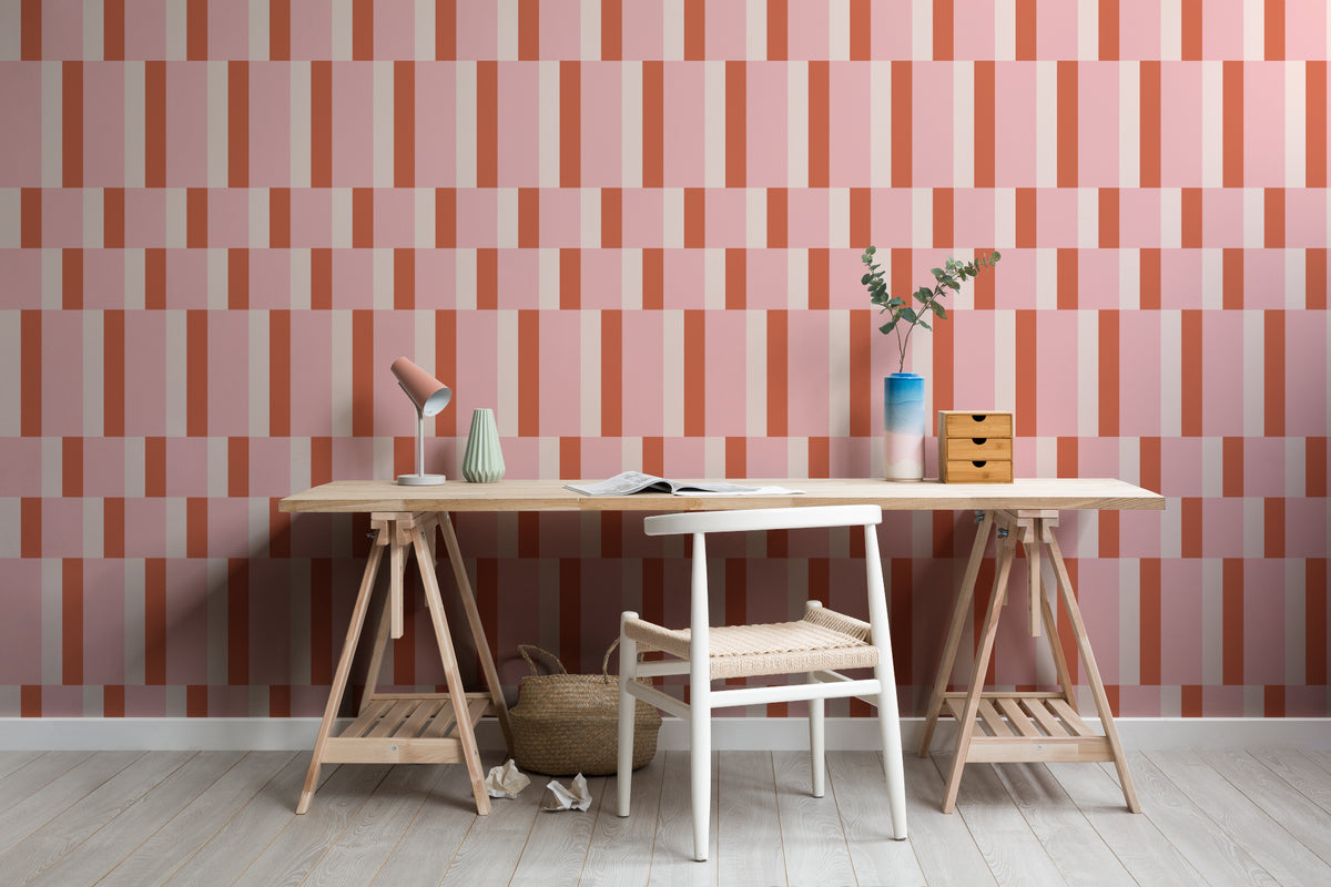 The Bauhaus Block wallpaper in rose and tangerine behind a desk in a home office