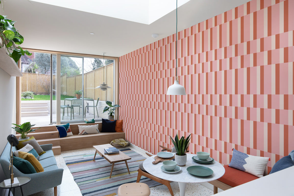 The Bauhaus Block wallpaper in rose and tangerine in a living room