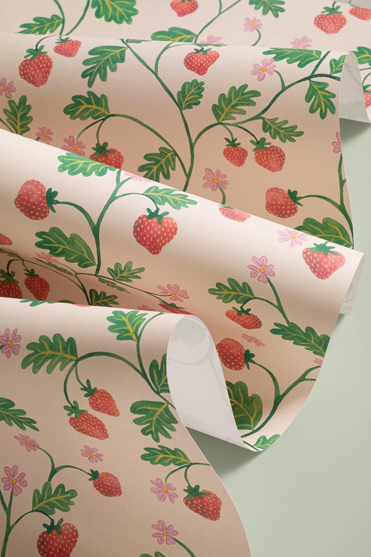 Angled detail of The Berry Arbour wallpaper in blush beige