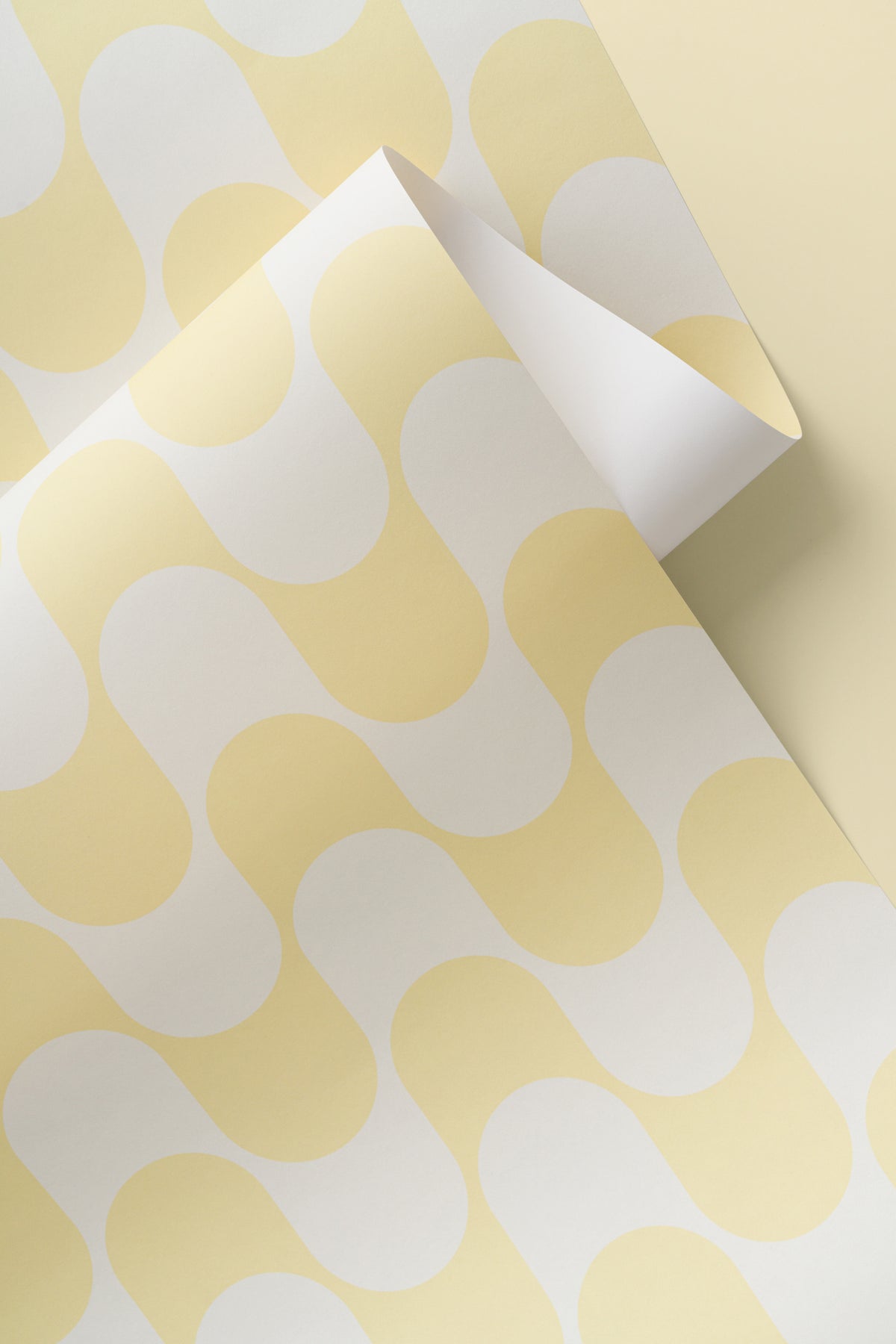 Angled detail of The Boardwalk Wave wallpaper in butter yellow