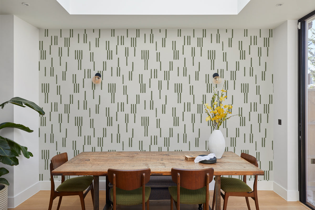 The Brushmark Column wallpaper in mossy green behind a dining table