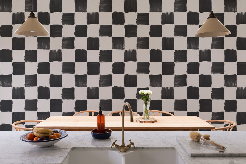 The Brushstroke Chequer wallpaper in onyx and beige behind seating in a living room