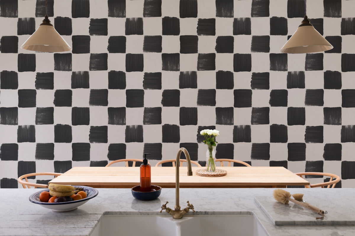 The Brushstroke Chequer wallpaper in onyx and beige behind seating in a living room