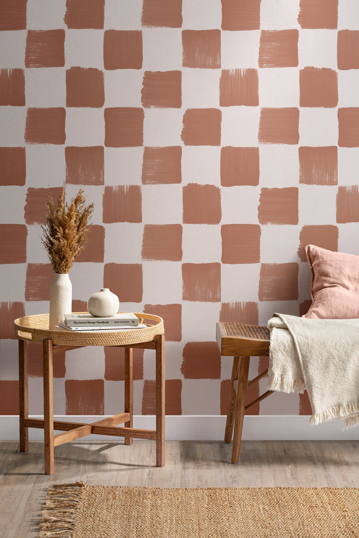 The Brushstroke Chequer wallpaper in terracotta behind a dining table