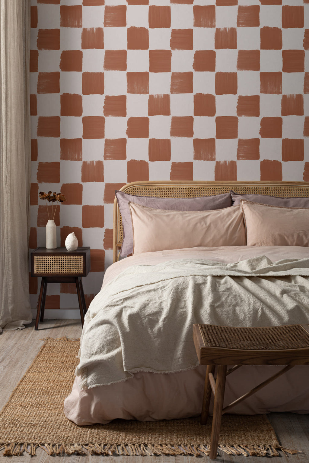 The Brushstroke Chequer wallpaper in terracotta behind the bed in a bedroom