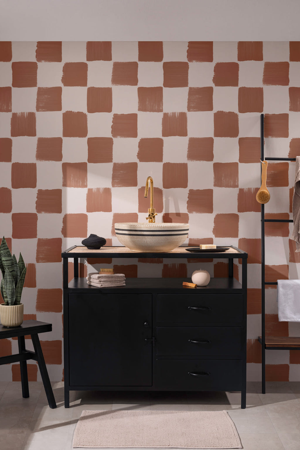 The Brushstroke Chequer wallpaper in terracotta behind a styled console