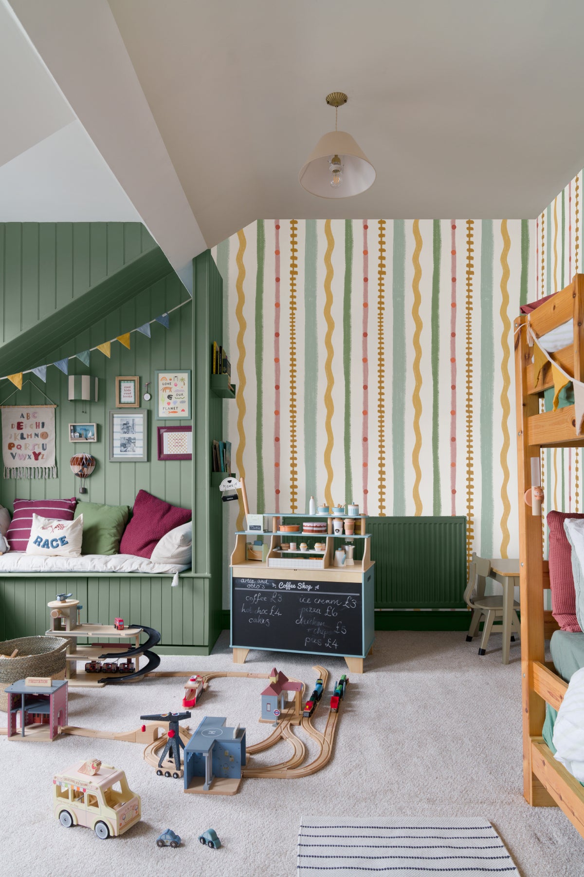 The Carousel Stripe mural in blush and pistachio in a child's bedroom