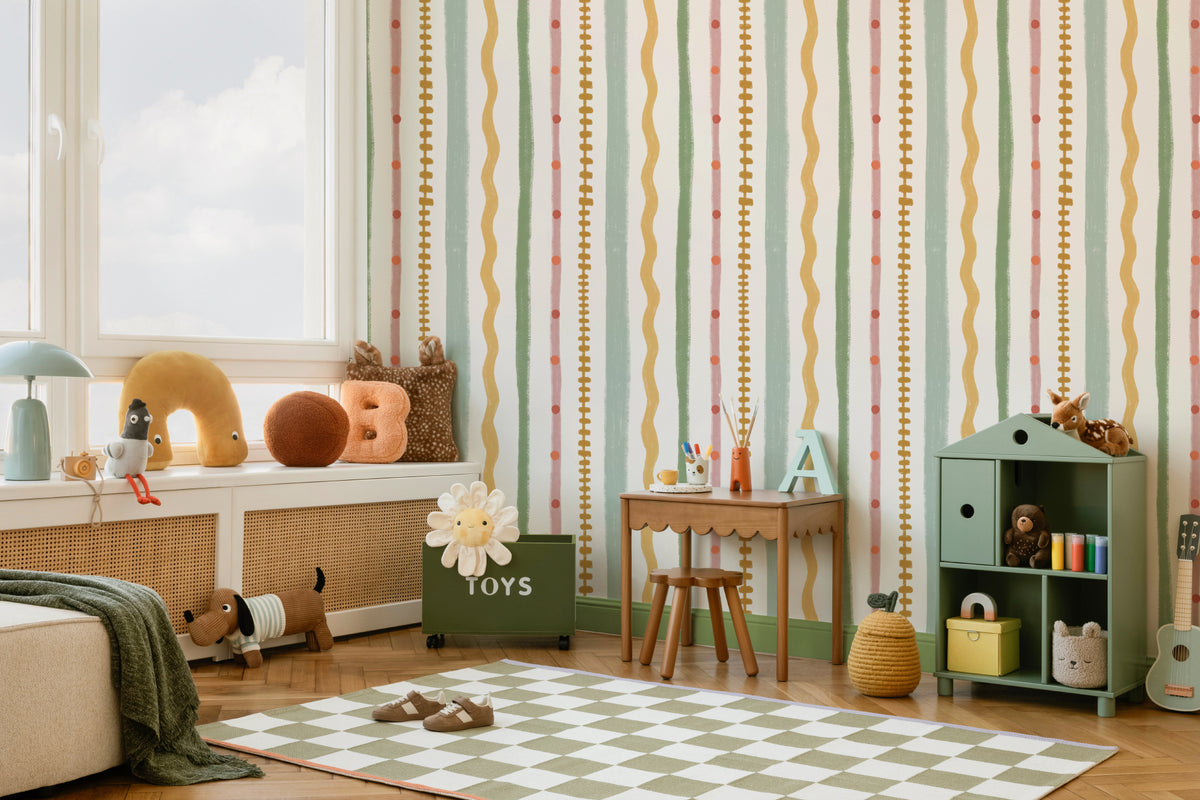 The Carousel Stripe mural in blush and pistachio behind a kids' play corner