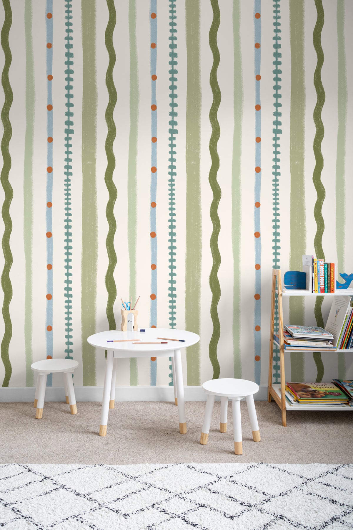 The Carousel Stripe mural in fern green and sand on a nursery wall