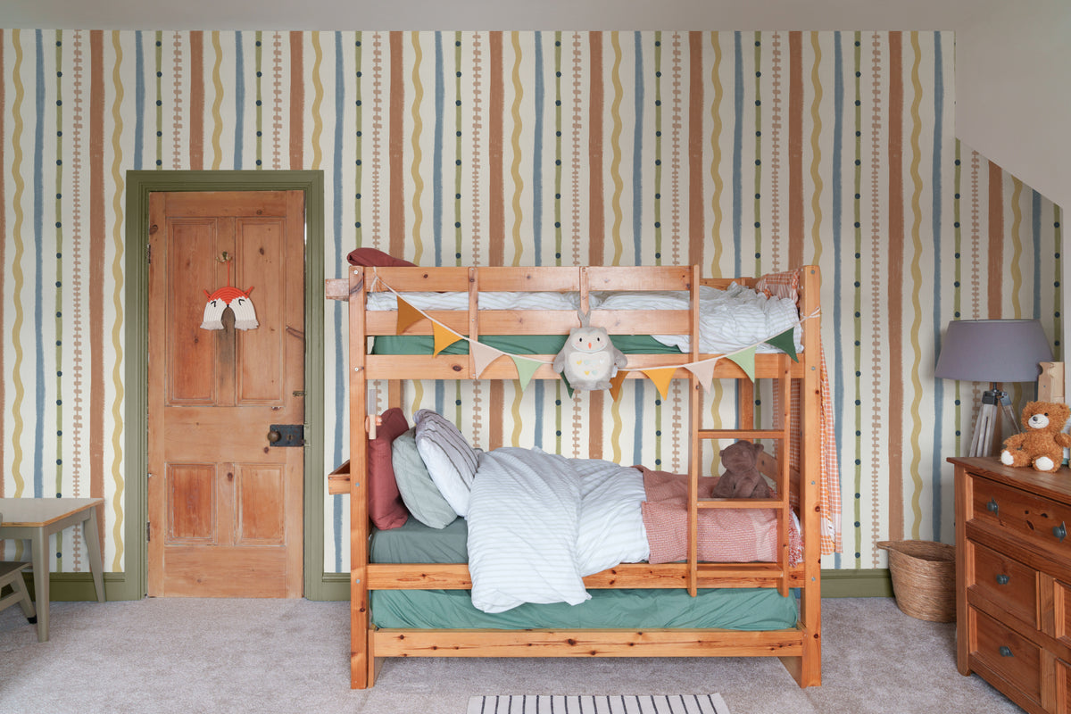 The Carousel Stripe mural in mustard and sky blue in a child's bedroom