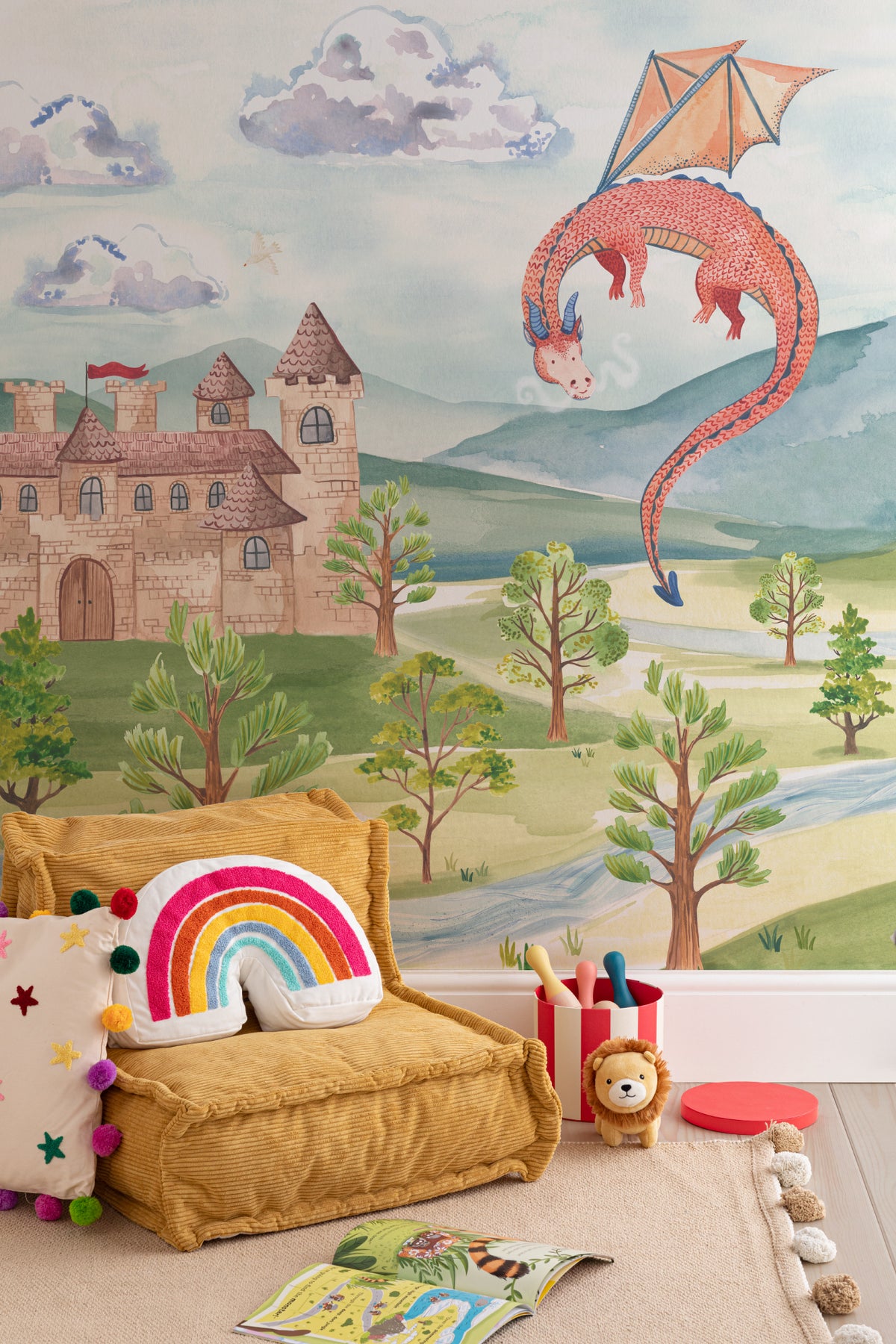 The Castle Storybook mural in dawn blue and meadow green behind a kids' play corner