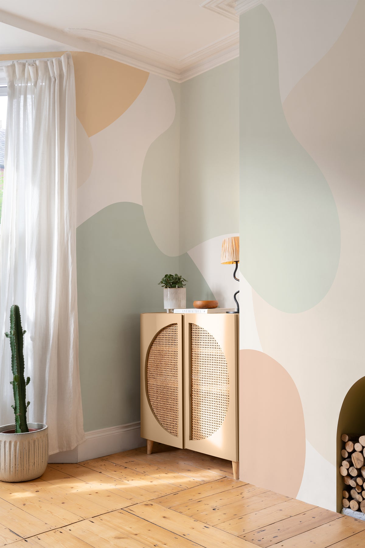 The Cloud Hills mural in sage and apricot behind a styled console