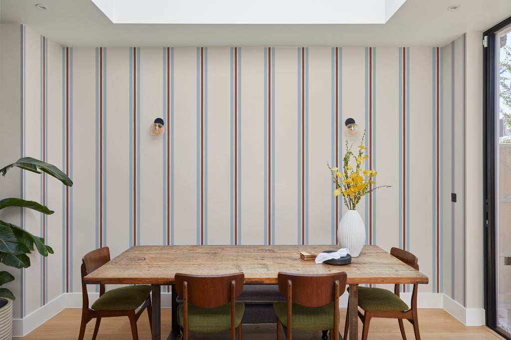 The Draughtsman Stripe wallpaper in sky blue behind a dining table