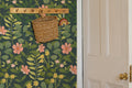 The Dusk Rosarium wallpaper in forest green and blush in a hallway