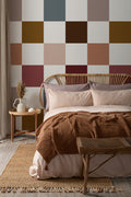 The Earthen Patchwork mural in clay and chocolate behind the bed in a bedroom