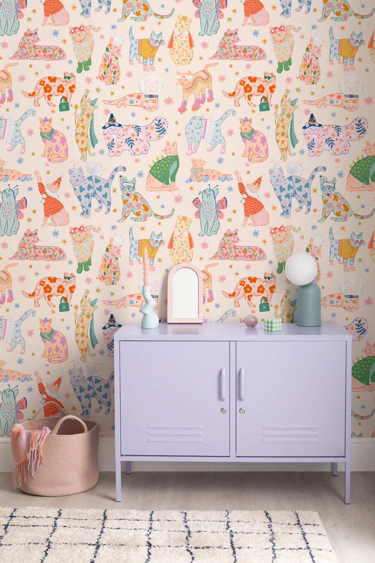 The Feline Wardrobe mural in sherbet pastel on a nursery wall
