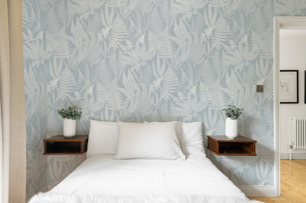 The Fernery Study wallpaper in duck egg blue behind the bed in a bedroom
