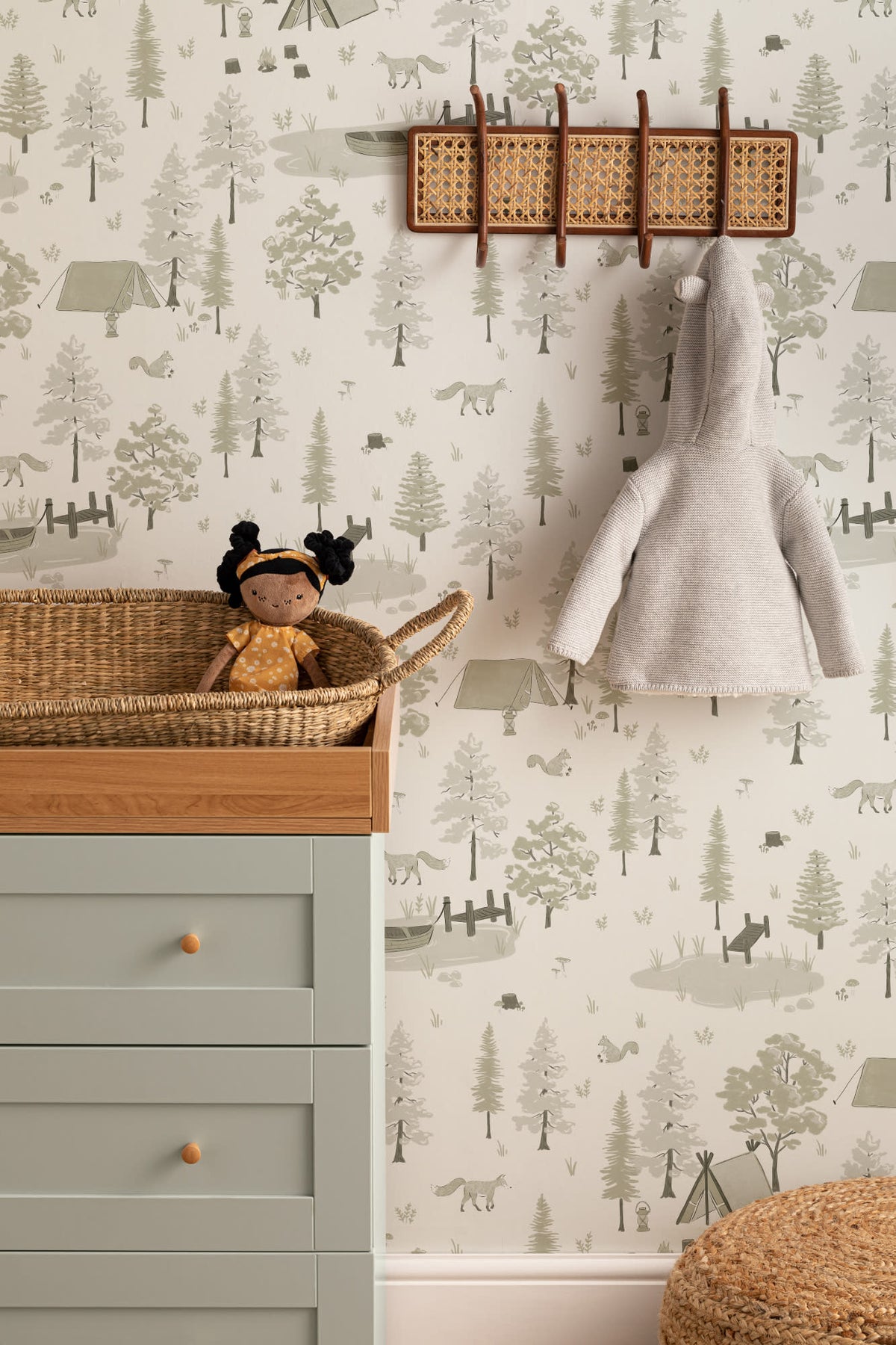 The Firelight Woods wallpaper in sage green on a nursery wall