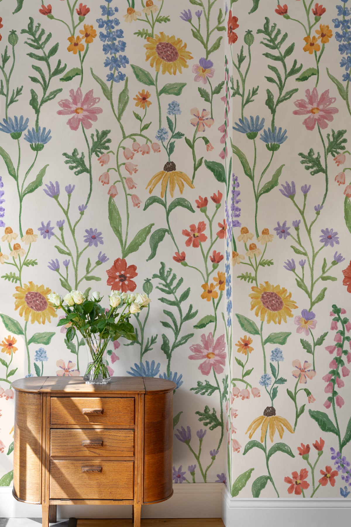 The Flower Almanac mural in cornflower and poppy behind a styled console