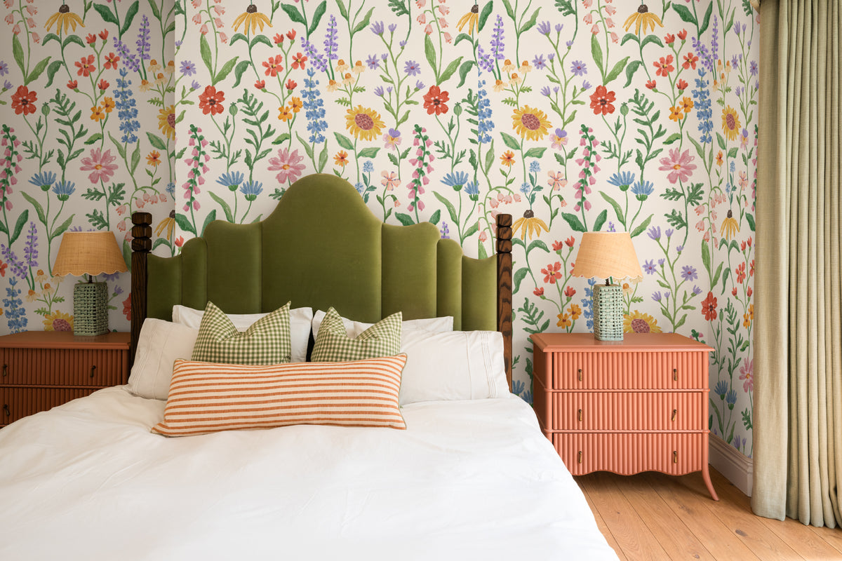The Flower Almanac mural in cornflower and poppy behind the bed in a bedroom