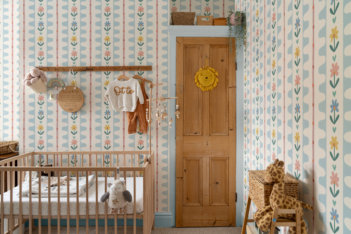 The Folk Garland mural in sky blue and buttercup behind a kids' play corner