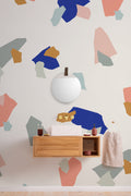 The Gallery Terrazzo mural in cobalt and coral behind a styled console