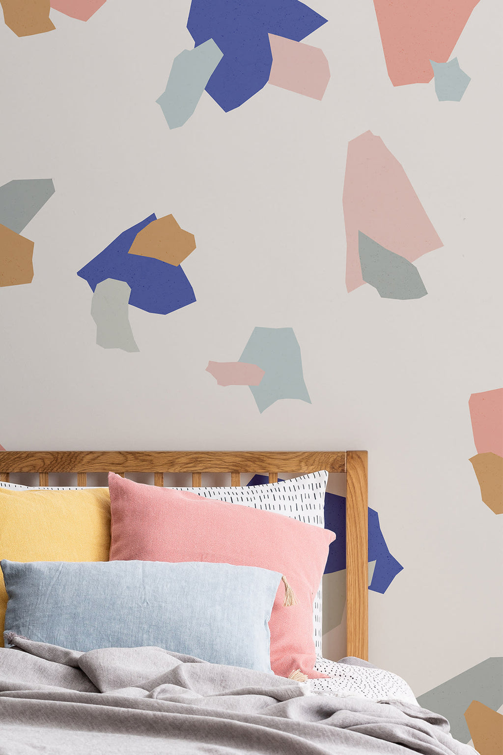 The Gallery Terrazzo mural in cobalt and coral behind the bed in a bedroom