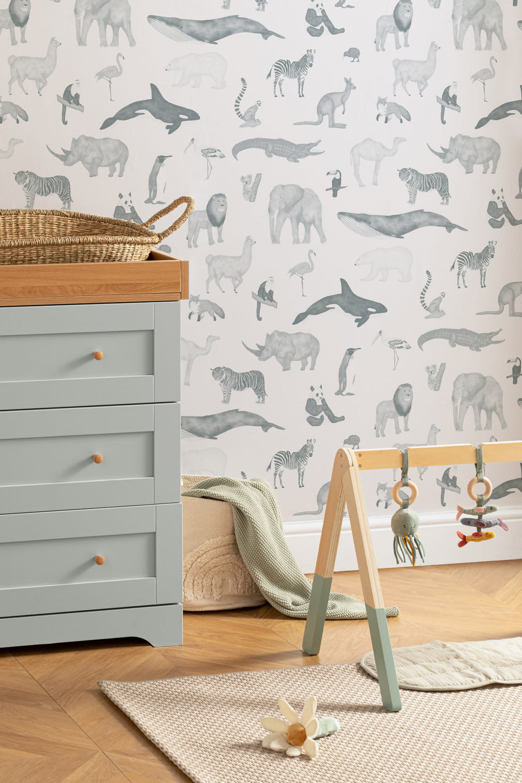 The Gentle Menagerie wallpaper in misty blue on a nursery wall