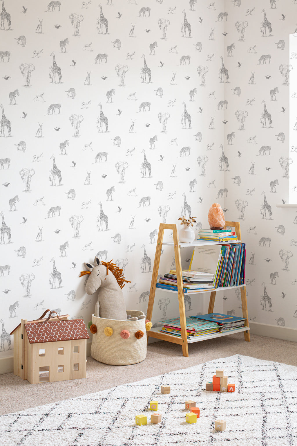 The Grassland Expedition wallpaper in dove grey and white behind a kids' play corner