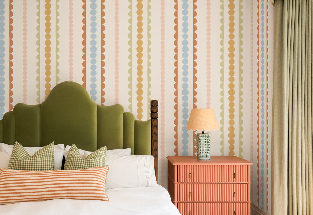 The Haberdashery Braid mural in apricot and pink behind the bed in a bedroom