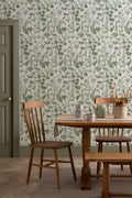The Hedgerow Botanica wallpaper in fern green and white behind a dining table