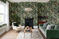 The Heliconia Hall wallpaper in deep jungle green in a living room