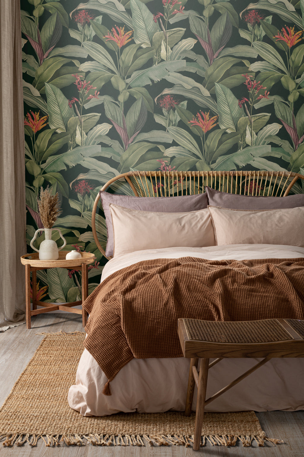 The Heliconia Hall wallpaper in deep jungle green behind the bed in a bedroom