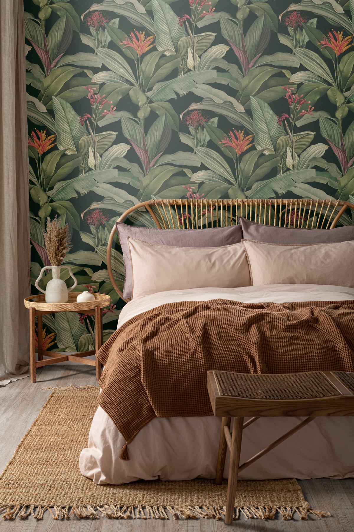 The Heliconia Hall wallpaper in deep jungle green behind the bed in a bedroom