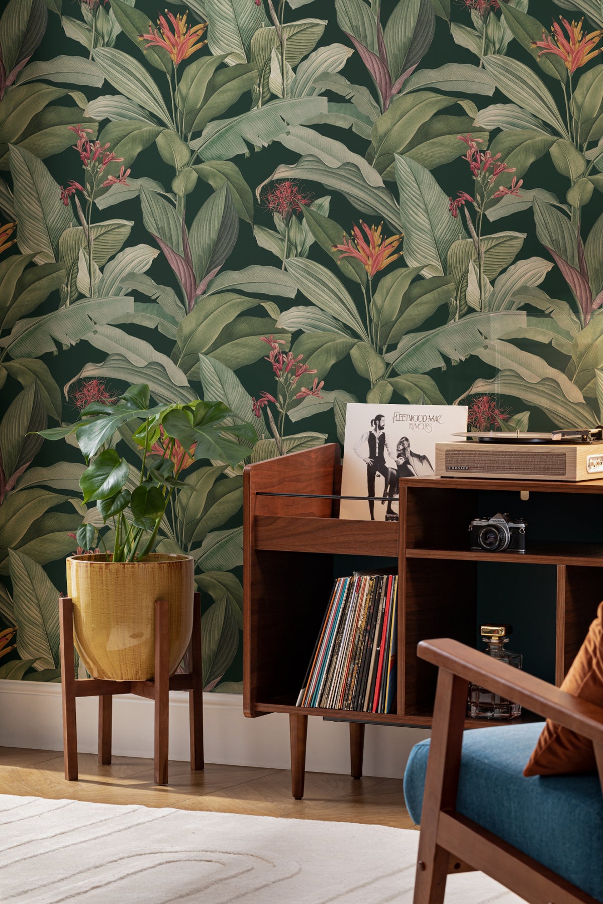The Heliconia Hall wallpaper in deep jungle green behind a desk in a home office
