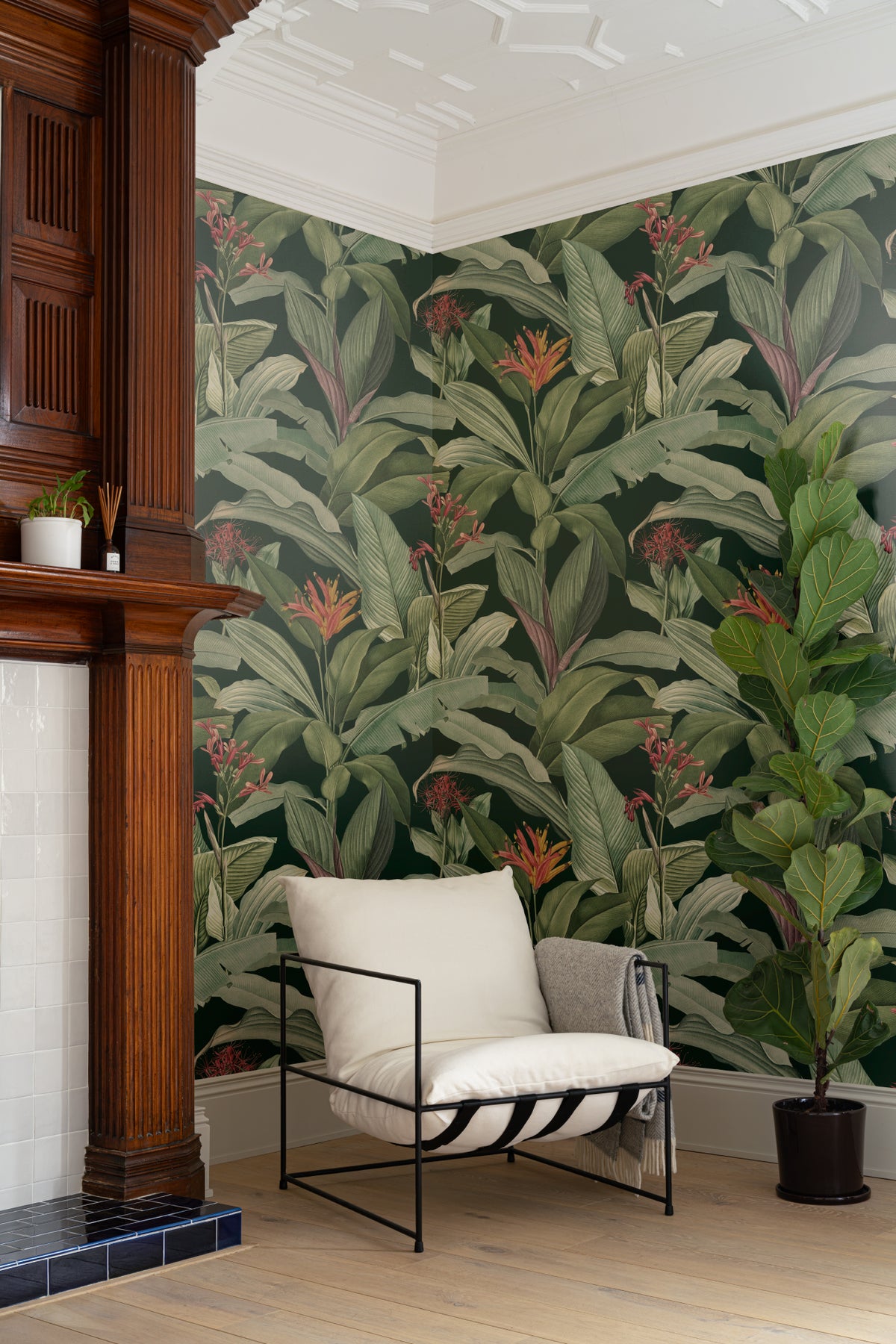 The Heliconia Hall wallpaper in deep jungle green in a lounge setting