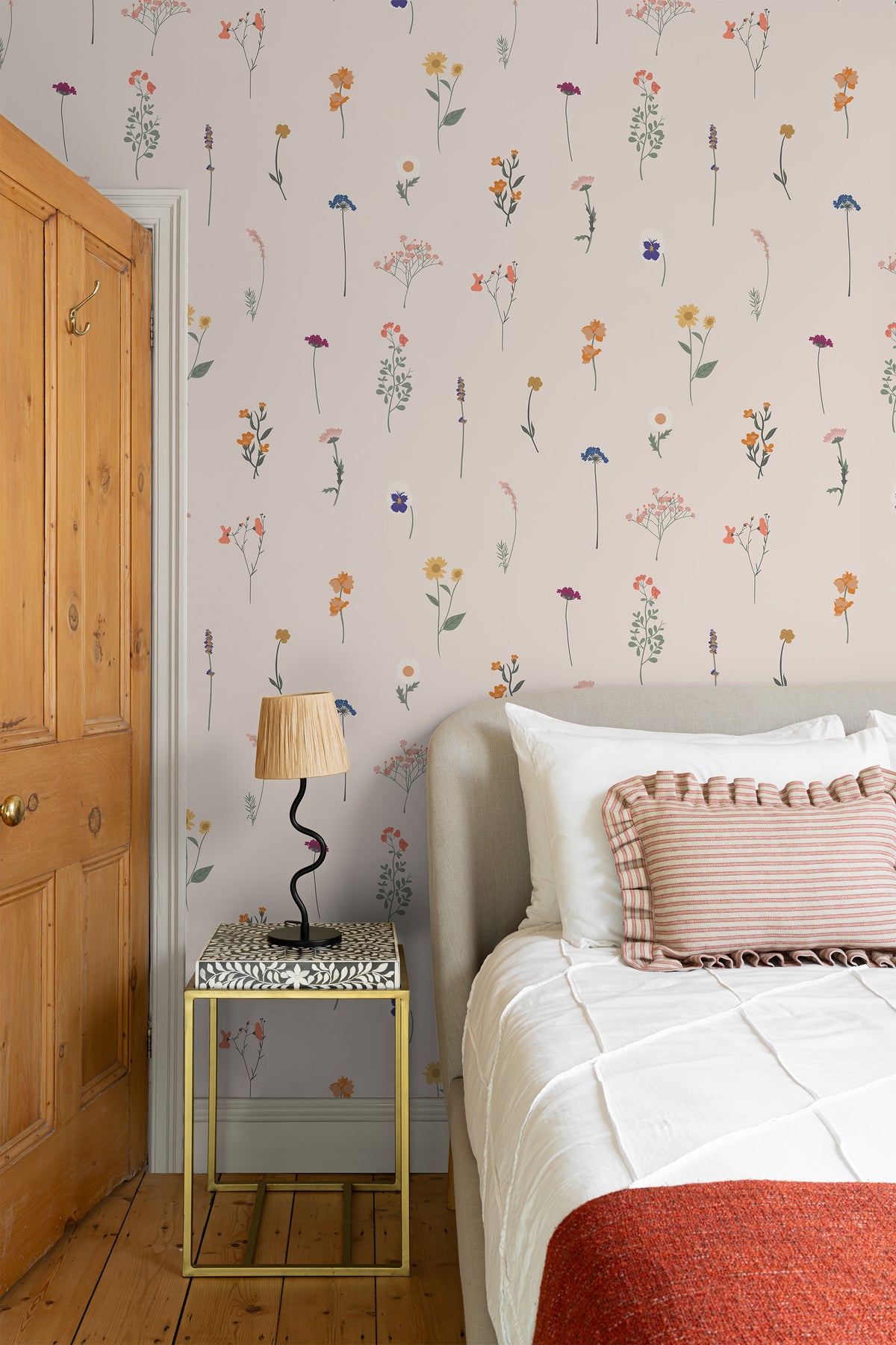 The Herbarium Press wallpaper in soft blush behind the bed in a bedroom