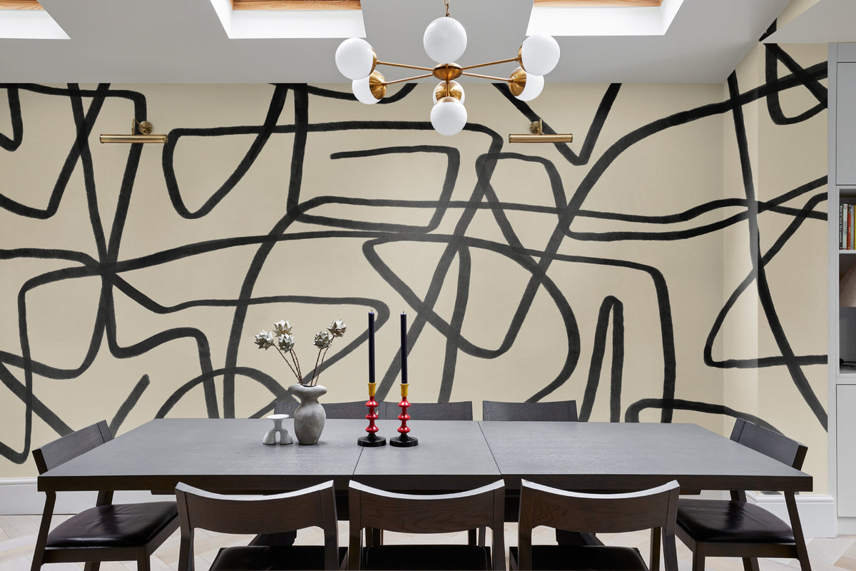 The Ink Gesture mural in black and parchment behind a dining table