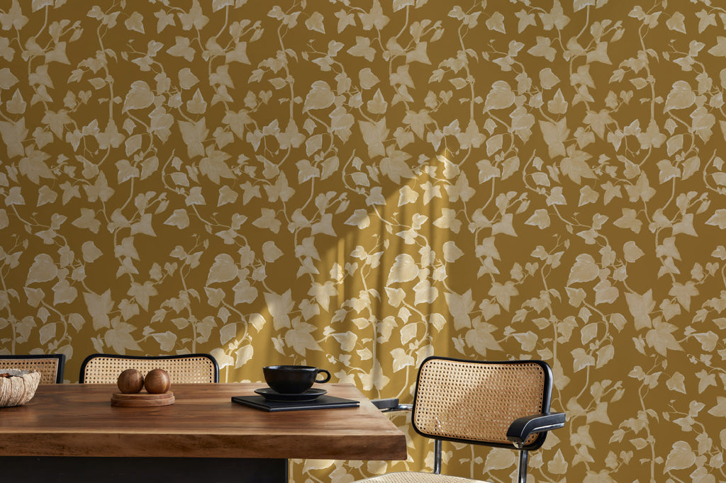 The Ivy Rectory wallpaper in mustard gold behind a dining table