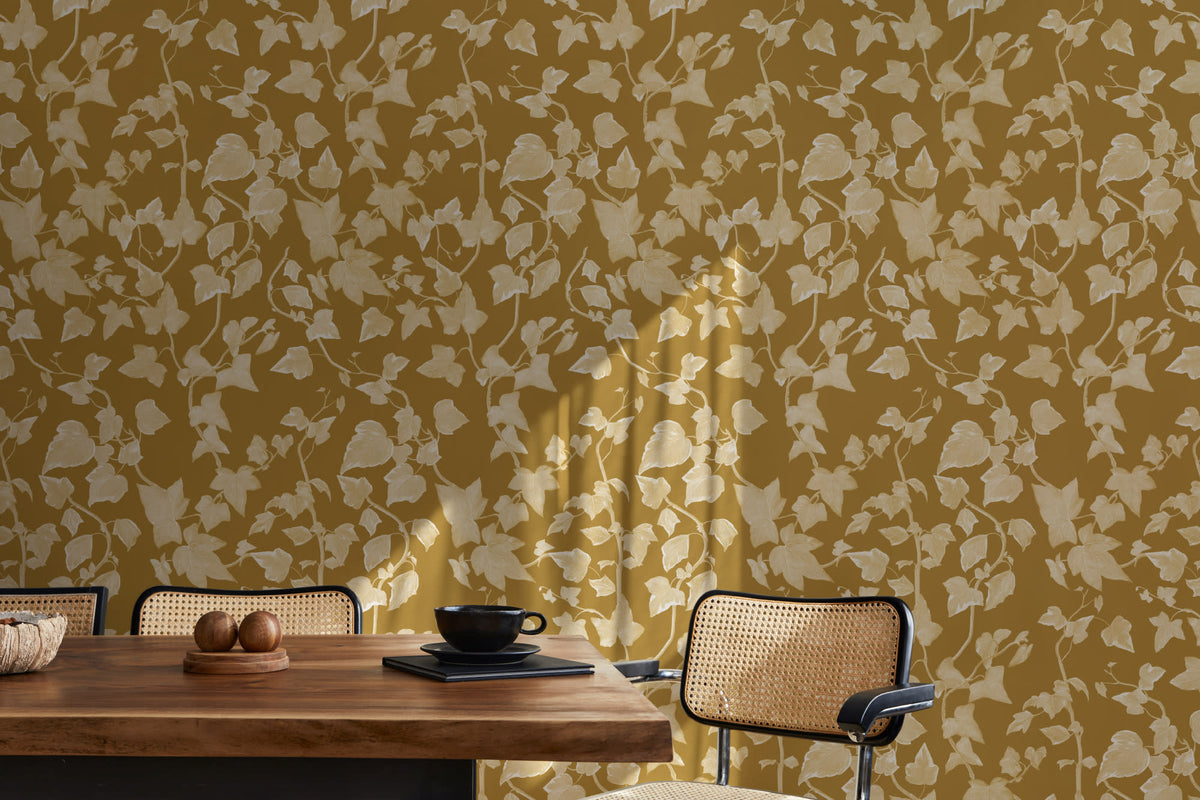 The Ivy Rectory wallpaper in mustard gold behind a dining table
