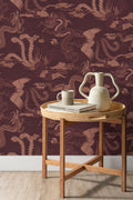The Lacquer Palace wallpaper in oxblood and rose behind a styled console