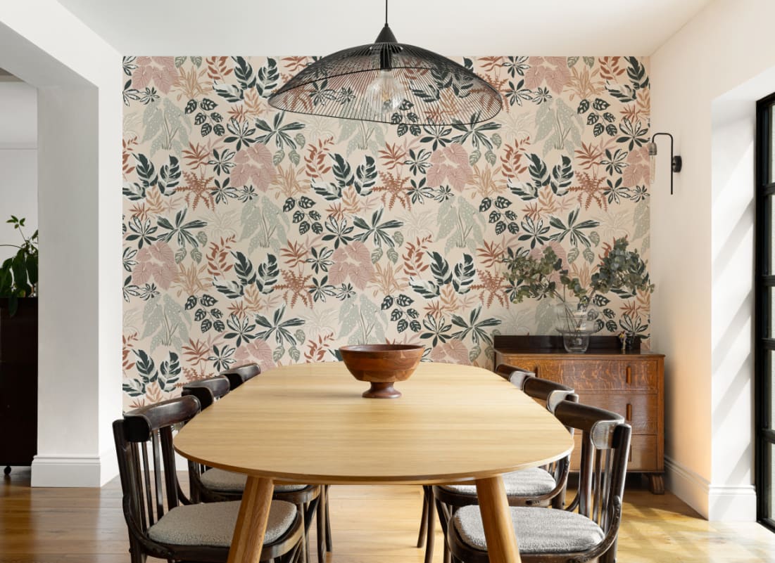 The Leafy Solarium wallpaper in warm sand and pine behind a dining table