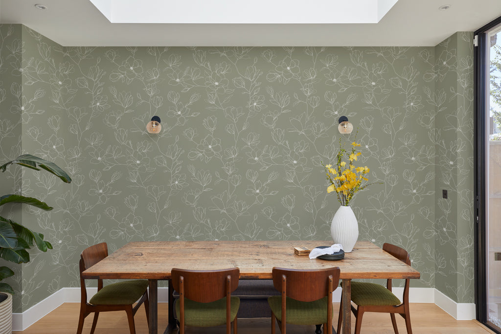 The Magnolia Sketchbook wallpaper in olive sage behind a dining table